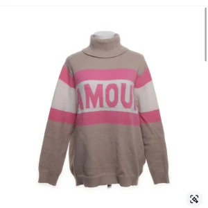 Ascool polotröja med text - Säljer en mysig polotröja i beige med rosa och vita ränder samt texten 'AMOUR' framtill. Perfekt för kyliga dagar med sin höga krage och långa ärmar. Påminner om Zadig tröjorna!!