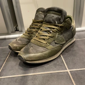 Philippe Model trainers - Riktigt snygga Philippe Model trainers i cammo/ grön färg. Skick 8/10! De är i stl 43 men passar även 42. Box,  dustbag och även lappar ingår! Original pris 3000+ , mitt pris endast 1500kr! 
