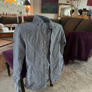 Ralph Lauren S - som ny - Snygg rutig skjorta från Ralph Lauren i blått och vitt. Skjortan har en broderad logga på bröstet och knappar framtill. Perfekt för en stilren look med sin slim fit passform.