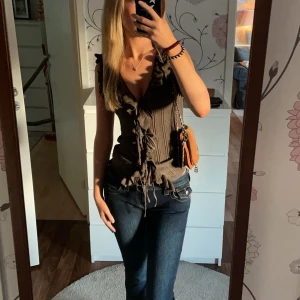 Grön ribbad topp med volangdetaljer - Snygg grön ribbad topp med volangdetaljer och knytning framtill. Perfekt för en trendig look, kommer från Zara och är i mycket bra skick. Varan har inga defekter. 