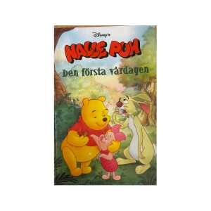 Nalle Puh: Den första vårdagen - En charmig barnbok från Disney med Nalle Puh och hans vänner. Boken heter 'Den första vårdagen' och har ett färgglatt omslag med Nalle Puh, Nasse och Kanin i en skogsmiljö. Perfekt för små barn som älskar äventyr i Sjumilaskogen.