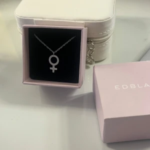 Halsband med kvinnosymbol  - Fint halsband från Edblad med kvinnosymbolen!! Aldrig använt då det inte riktigt va min stil! Passar perfekt som julklapp eller present💝  ORGINAL PRIS: 349kr