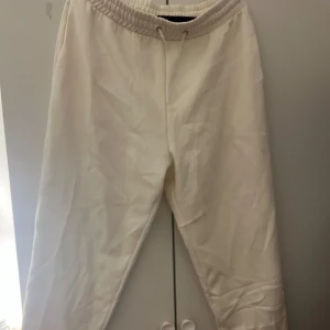 Vita mjukisbyxor från 157 - Säljer ett par vita mjukisbyxor från 157 i storlek XL. Byxorna har en elastisk midja med snörning för justerbar passform. Perfekta för en avslappnad stil.