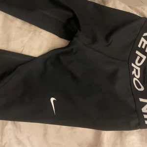 Svarta tights från Nike - Snygga svarta tights från Nike med vit logga och text på midjebandet. Perfekta för träning med en tight passform som ger bra stöd. Etikett är bortklippt men de är i storlek xxs/xs!💗skriv om ni har funderingar🩷de har inga skavanker OBS säljer då det är för korta på mig !