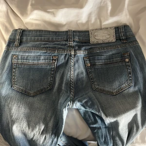 Lågmidjade bootcut jeans från Goodies - Snygga lågmidjade blå jeans från Goodies. Midjemått: 40cm, innerbensmåttet: 82cm. Supersnygga!! Bara att höra av dig om frågor🩷 Andta bilden är lånad från tidigare ägaren 
