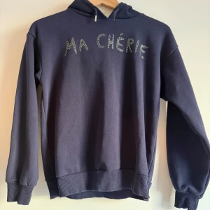Hoodie från Gina Tricot  - Mörkblå hoodie från Gina Tricot  'MA CHÉRIE'. Mycket fint skick storlek 134 140