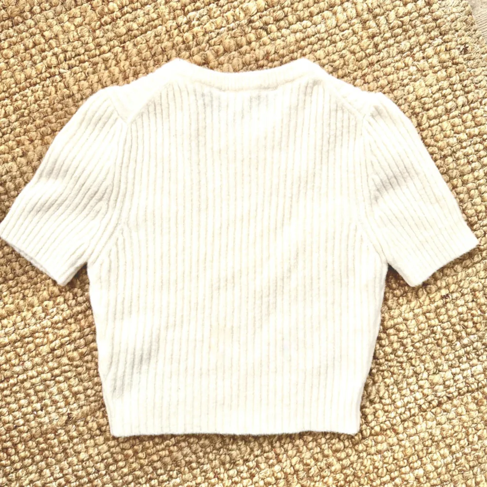 New with tags- SHORT SLEEVE RIBBED KNIT SWEATER  Cropped sweater with round neck and short sleeves. Size S/36.    OUTER SHELL 54% polyester 34% acrylic 10% wool 2% elastane  Never used, with tags.. Toppar.