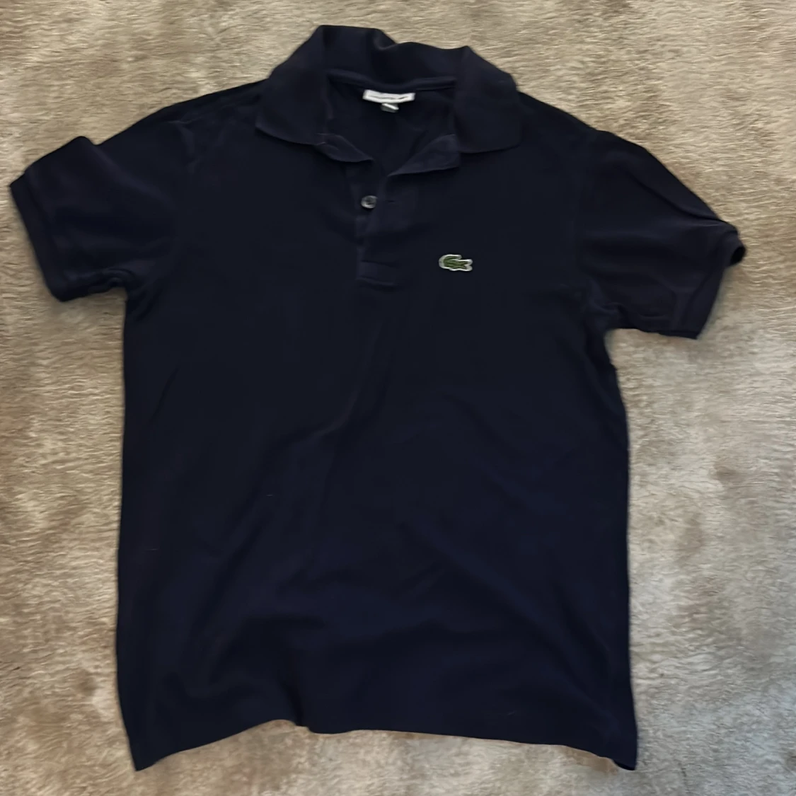 Mörkblå pikétröja från Lacoste