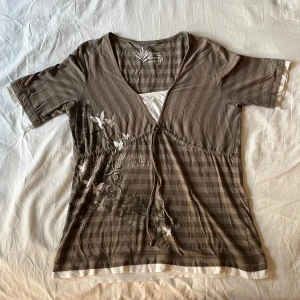 y2k t-shirt/topp - Brun & vit randig topp som går att dra åt med snörning! 90/00s stil & passar både M/L (står 44/46) väldigt fint skick🫶 säljer för att den tyvärr inte kommer till användning!