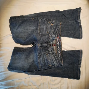 Lågmidjade bootcut jeans av esprit! - Säljer dessa jättefina lågmidjade utsvängda jeanen av märket esprit!! Massor av snygga detaljer! Säljer för att dom tyvärr inte passar mig💔. Dom var inte bootcut från början. Midjemåttet är 40 cm och innerbensländen är 83cm Kontakta mig vid frågor 💕