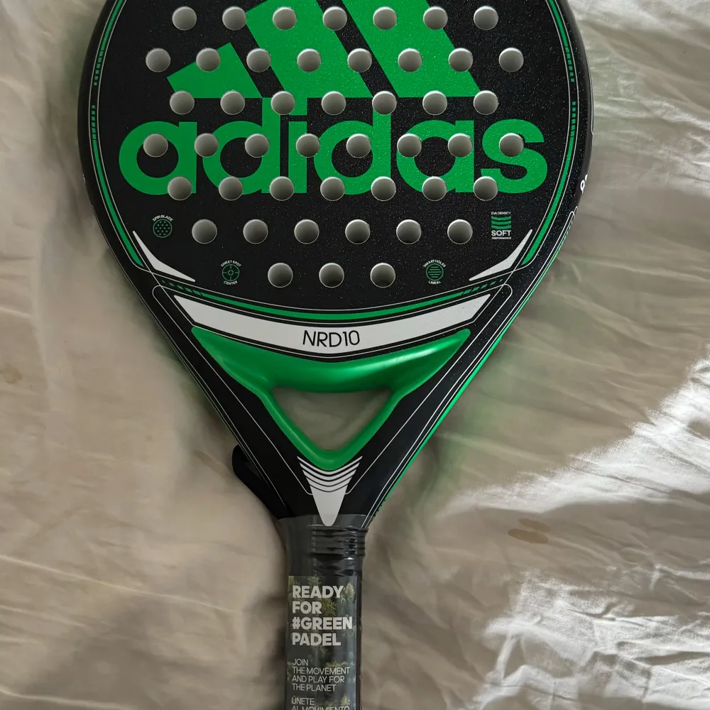 Säljer ett Adidas padelracket i svart och grönt. Racketen har en cool design med stora gröna Adidas-loggor och vita detaljer. Perfekt för både nybörjare och erfarna spelare som vill ha en pålitlig racket. Greppet är bekvämt och racketen är redo för spel direkt. Passar perfekt för den som vill dominera på padelbanan!. T-shirts.