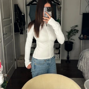 Vit Zip Up  - Säljer nu min vita zip up topp från Nelly. 💕 Liknar och är samma stil som the ”bbl” jacket. 🥰 Original pris: 349kr 😇