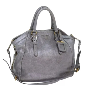Prada väska - Ursprung: Italien  Material: läder Färg: silver Tillbehör: namnskylt och axelrem    Några små tecken på användning, men överlag mycket bra skick. Se bilder för detaljer! B 29cm x B 28cm x D 10cm