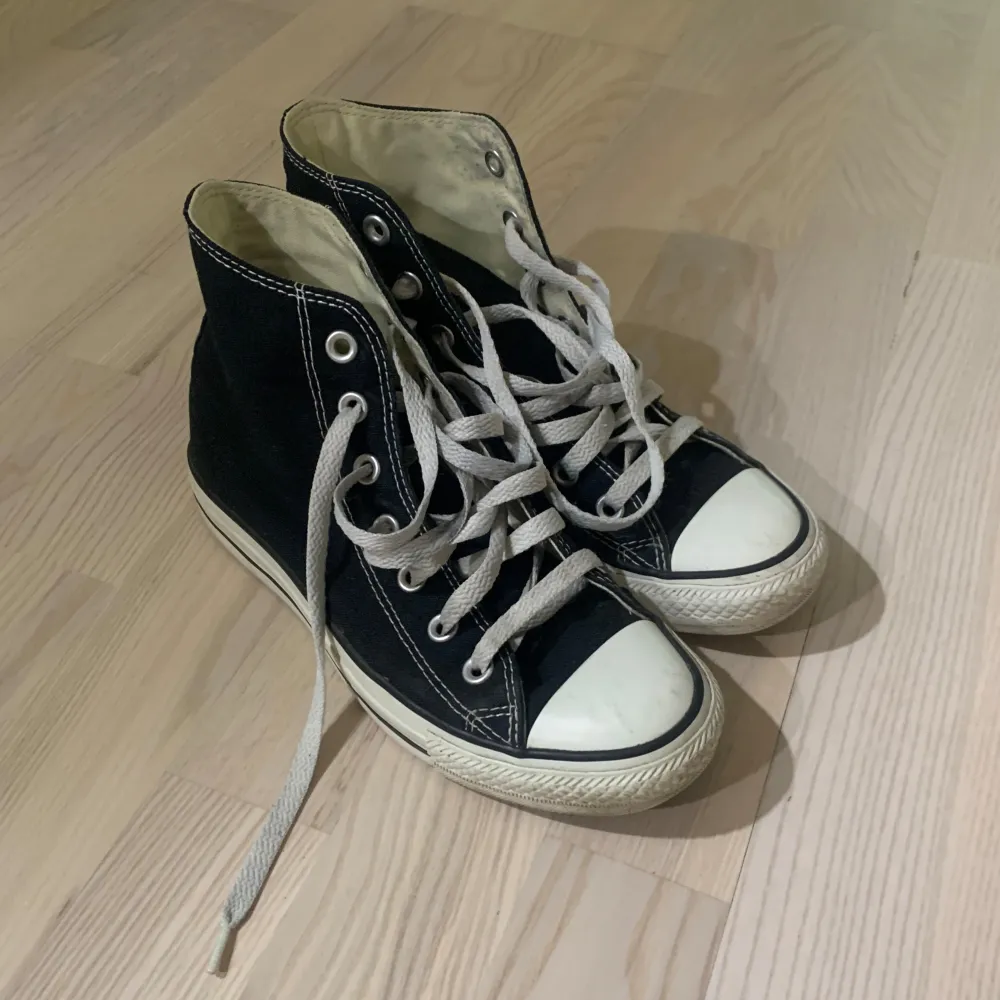 Säljer ett par klassiska svarta Converse All Star sneakers i storlek dam 36. De är i unisex-modell med textilmaterial både på utsidan och insidan. Skorna har den ikoniska vita gummisulan och snörning framtill 🤍. Skor.