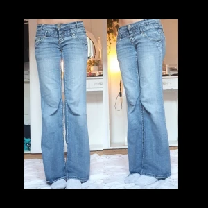 Blå lågmidjade bootcut jeans  - Super snygga lågmidjade bootcut ☆  Som du ser på sista bilden så har jeansen ingen gylf så jag sydde på en knapp och klippte ett hål som ersättning♡ dessutom finns det en liten grön fläck på byxan av penna men det märks inte! Midja: 40cm Innerben:81 