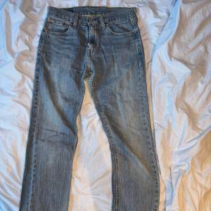 Säljer ett par klassiska Levi's 505 jeans i blå denim. De har en straight passform och är i storlek W29 L30. Perfekta för en avslappnad stil och passar till det mesta. Jeansen är i bra skick men har några små hål vid bakfickorna.