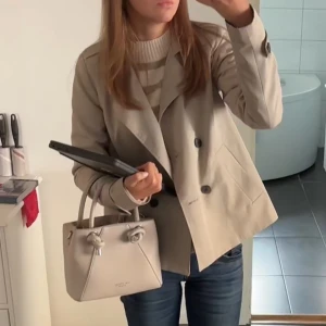 Beige kavaj från Vila - Snygg beige trenchcoat från Vila. Den har en klassisk design och långa ärmar. Perfekt för både vardag och lite finare tillfällen. Kavajen är i bra skick och passar perfekt till höstgarderoben. Superfint skick, använt två ggr!🧸Passar xs/s