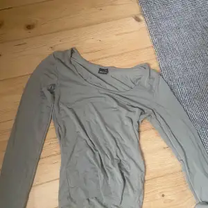 Säljer en stilren beige långärmad topp från Gina Tricot. Den är i ett mjukt och bekvämt material, perfekt för både vardag och lite finare tillfällen. Toppen har en enkel design med en rundad halsringning.