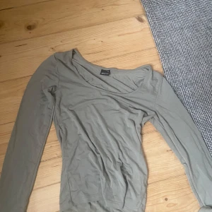 Beige långärmad topp från Gina Tricot - Säljer en stilren beige långärmad topp från Gina Tricot. Den är i ett mjukt och bekvämt material, perfekt för både vardag och lite finare tillfällen. Toppen har en enkel design med en rundad halsringning.