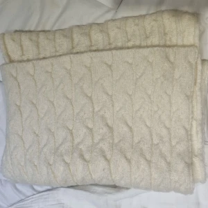 Vit halsduk - Mysig vit stickad halsduk med ett klassiskt flätmönster. Perfekt för att hålla värmen under kyliga dagar. Den neutrala färgen gör den lätt att matcha med olika outfits. Tjock och bra för vinter