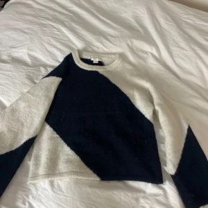 Svart och vit stickad tröja - Säljer en stilren svart och vit stickad tröja med ett diagonalt mönster. Tröjan har långa ärmar och en rund halsringning. Perfekt för kyligare dagar. Aldrig andvänd, lånade bilder!!💞💞