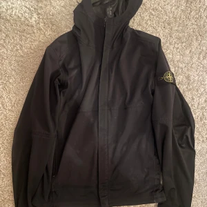 Svart softshelljacka från Stone Island - Säljer en riktigt snygg svart softshelljacka från Stone Island. Jackan är vatten- och vindtålig med en andningsbar design. Perfekt för varierande väderförhållanden. Säljer då jag inte använder den längre. Nypris 6000.