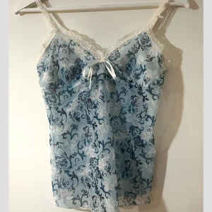 Linnetopp - Säljer en söt blå linnetopp från TCM med ett vackert mönster och spetsdetaljer, säljer därav den ej kommer till användning💔 inga defekter som nyskick🩵strorlek ca 36/38