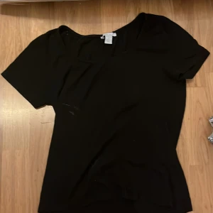 Svart topp från Amisu - Säljer en stilren svart topp från Amisu i storlek S. Toppen har korta ärmar och en klassisk design som passar perfekt till olika tillfällen. Tillverkad i Turkiet.