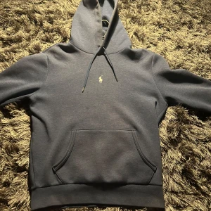 Mörkblå hoodie från Ralph Lauren - Säljer en stilren mörkblå hoodie från Ralph Lauren. skicket är 9/10, i storlek S, men sitter som en större Small. Priset är 999kr nu runt 2lax. Skriv gärna för fler bilder elr frågor(: