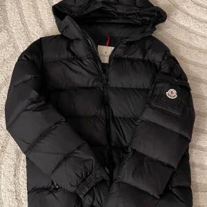 Moncler Marque Giubbotto Jacka - Säljer en snygg svart dunjacka från Moncler med huva och dragkedja. Det finns små tecken på användning men annars bra skick! Vill bara få den såld då den tar mycket plats i min garderob så alla bud är intressanta sålänge de är rimliga. Hör av er för frågor! ‼️Skriv innan köp‼️
