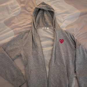 Cdg zip up - Säljer en grå Cdg zip i bra skick!  Jag på bilden är 176 och den passar perfekt.           Obs!! Den är motsatsen till äkta därav det låga priset! 😇