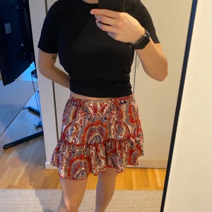 Mönstrad kortkjol med volang - Kjolen går till mitten av låren på mig (jag är 168 cm). Köpt på second hand, den har inga lappar os äv så vet ej märke och storlek. 