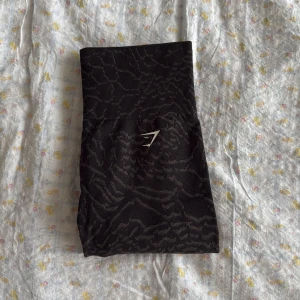 gymshark tights - Finaste scrunch tightsen som inte går att få tag i längre. Modellen visas på sista bilden från hemsidan men mönstret är inte det samma. Dessa har ett snyggt djur mönster som passar perfekt med årets trender. Strl S men passar både XS och M!!🫶🏼
