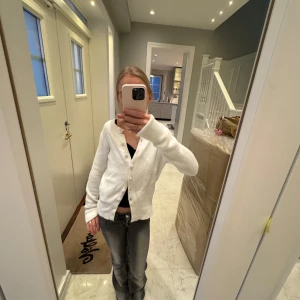 Vit kofta från Zara med pärlknappar - Säljer en stilren vit kofta från Zara med dekorativa pärlknappar. Koftan har långa ärmar och en mjuk, bekväm passform. Perfekt för att lägga till en touch av elegans till din outfit. Hör av dig vid intresse! 🤍