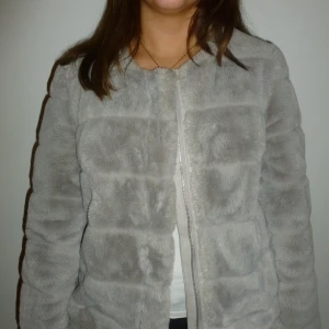 Grå pälsjacka - Vi Säljer en stilren grå pälsjacka med dragkedja. Jackan har en mjuk och fluffig yta som ger en lyxig känsla.🧖‍♀️ Perfekt för kyligare dagar när du vill hålla dig varm och snygg. 👌🏽