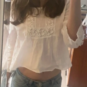 Vit blus från Zara  - Jätte söt vit blus från Zara. Köptes för länge sedan från sellpy. Fina blomm detaljer vid bröst rygg och armarna. Uppsydd eftersom den var väldigt lång. Lite genomskinlig. 