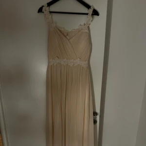 Balklänning från Bubbleroom - Superfin, champagnefärgad, lång klänning från Bubbleroom, med öppen rygg och spetsdetaljer, som användts en gång! Klänningen är i storlek 38/M, i mycket bra skick! Perfekta balklänningen 😍Skriv för fler bilder 🫶🏼
