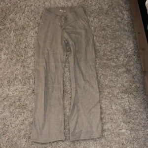 Beige mjukisbyxor från Gina Tricot - Säljer ett par bekväma beige mjukisbyxor från Gina Tricot. Byxorna har en låg midja med snörning och är tillverkade i ett mjukt material. Perfekta för en avslappnad stil.