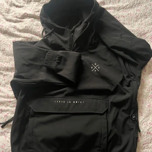 Svart jacka från Dope - Säljer en svart jacka från Dope med dragkedja och en stor ficka framtill. Jackan har en stilren design med Dope-logga på bröstet. Insidan är fodrad med mjukt material för extra komfort. Perfekt för kyligare dagar.