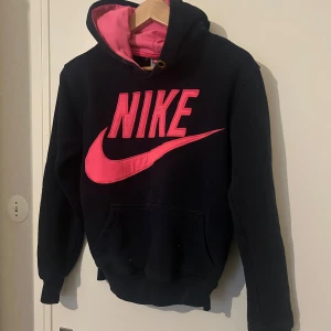 Svart och rosa hoodie från Nike - Säljer en svart hoodie från Nike. Jätte fin och bekväm tröja passar som S-M