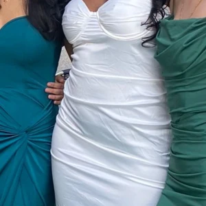 Vit tight klänning med slit - Säljer en superfin vit klänning som är tight och figurnära. Klänningen är silk och har en inbyggd BH. Har bara haft på den 1 gång då den var för stort på mig🩵🩵 passar även till de vita XIT klackar som jag säljer🤭😉Skriv till mig man vill ha mer info som längd