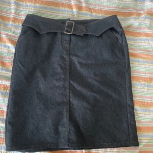 Svart jeanskjol från Gerry Weber - Säljer en snygg mörkblå jeanskjol från Gerry Weber i storlek L. Kjolen har en cool bältesdetalj i midjan och är perfekt för både vardag och fest. Den är i nyskick och har en normal passform. Materialet är robust jeans som gör att den håller länge. Passar perfekt till höst- och vårsäsongen! nypris 1400kr 