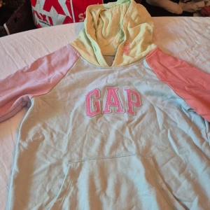Färgglad hoodie från GAP Kids - Säljer en superfin och färgglad hoodie från GAP Kids i storlek XXL. Den har en ljusgul huva, ljusblå kropp och rosa ärmar. GAP-loggan är broderad i rosa på bröstet. Perfekt för höst och vår, och den är i nyskick! 🧡