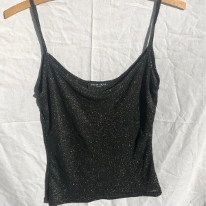 Guldglittrigt linne - Gulligt svart linne med guld i! Stretchigt så passar xs-m