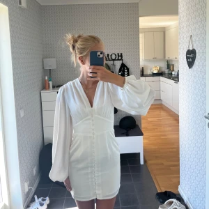 Vit klänning - Säljer en jättefin vit klänning från na-kd. Använd två gånger och i jättebra skick💕den passar perfekt till antingen en avslutning, midsommar eller en sommardag 🌷nypris: 699kr mitt pris: 300kr + frakt