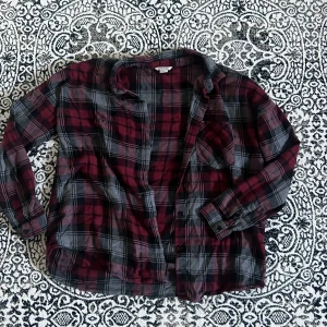 Flanellskjorta  - Grå/svart/röd flanellskjorta från Monki. Skönt material och har en rätt loose och avslappnad passform. Bra skick i strl M.