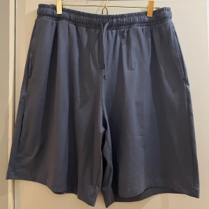 SKIMS - NWT: Shorts (Strl L) - Herrshorts från SKIMS, nypris 845 kr. Storlek L. NWT (New with tags), endast provade.  Namn: Mens relaxed short (Outdoor Jersey) Länk till produkt: https://skims.com/products/outdoor-jersey-mens-relaxed-short-steel-blue    