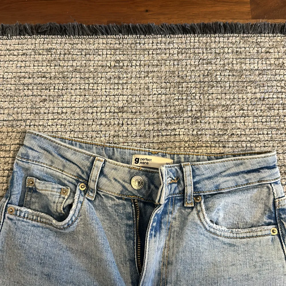 Säljer ett par ljusblå jeans från Garment Project. De är i bra skick och har en klassisk femficksdesign med knapp och dragkedja framtill. Jeansen är raka i modellen och har en normal passform. Perfekta för vardagsbruk!. Jeans & Byxor.