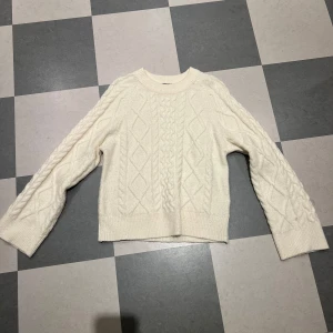 Vit stickad tröja från Gina Tricot - Säljer en superfin vit stickad tröja från Gina Tricot i storlek S. Tröjan har ett snyggt flätmönster och är perfekt för höst och vinter. Den är långärmad och väldigt mysig att ha på sig. Perfekt för kalla dagar! ❄️