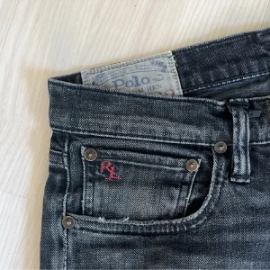 Polo Ralph Lauren jeans - Snygga svarta jeans från Polo Ralph Lauren med en diskret tvättad look. De har den röda RL loggan broderad på fickan. Slimfit passform, storlek W29/L32. Perfekta för en stilren och avslappnad look. Pris går att diskutera vid affär.
